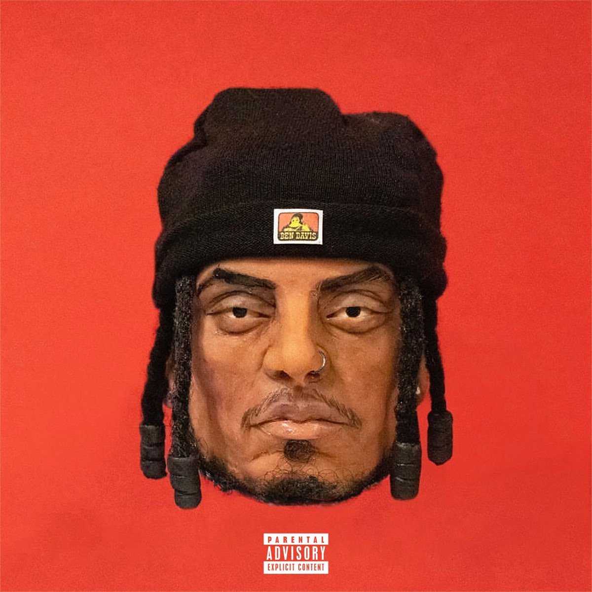 Ramirez - The Warlock and the Gorilla album cover with the artists head as a claymation style wearing a ben davis beanie and hair braids and a nose ring on a red background with a parental advisory logo at the bottom